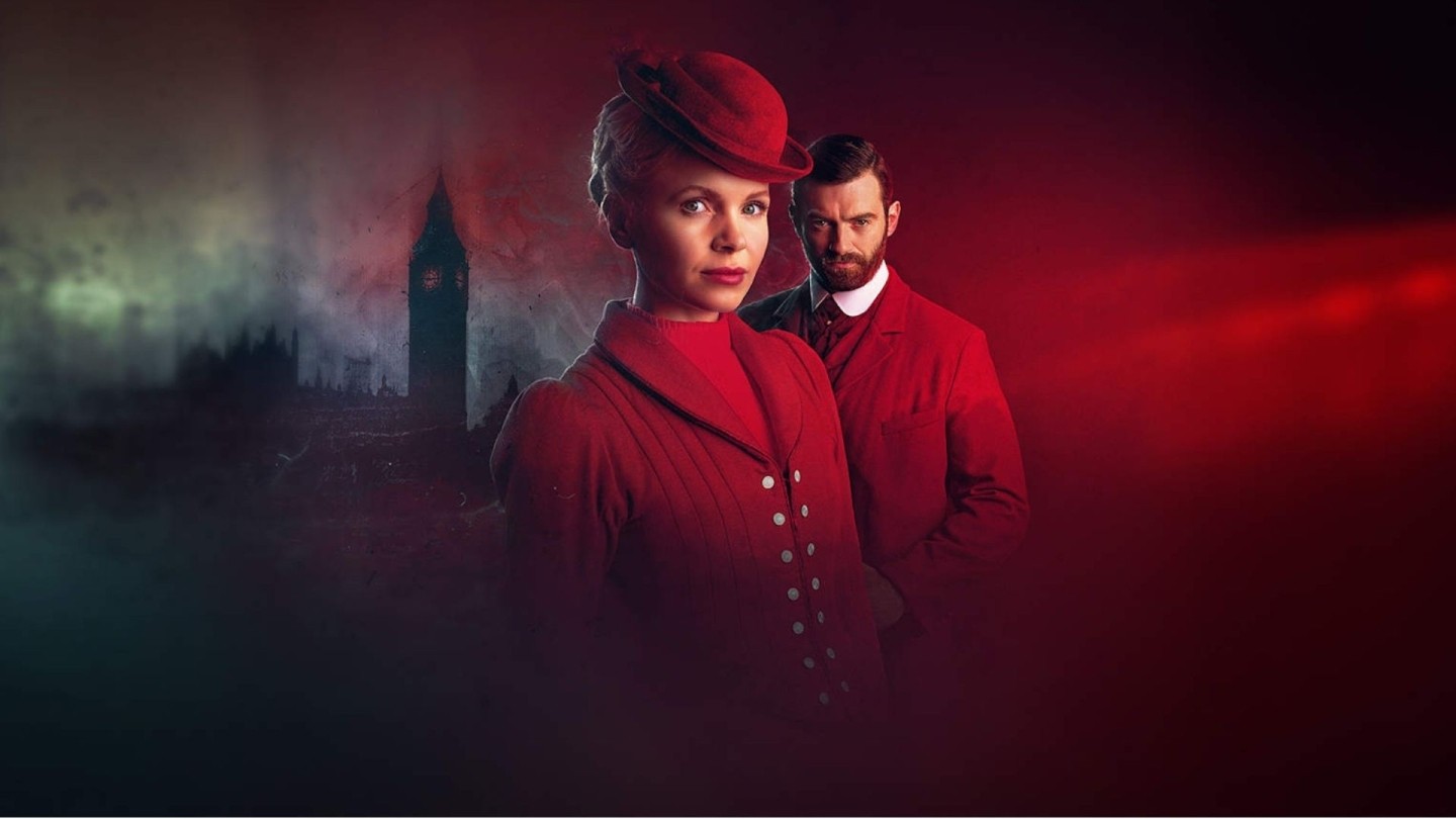Promotional image from Miss Scarlet and The Duke showing two Victorian detectives in red-toned period costume against a dramatic London backdrop.
