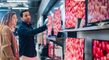 A person being shown televisions in a store