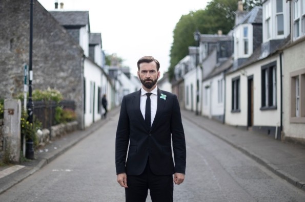 David Tennant stood in the middle of a street in Deadwater Fell