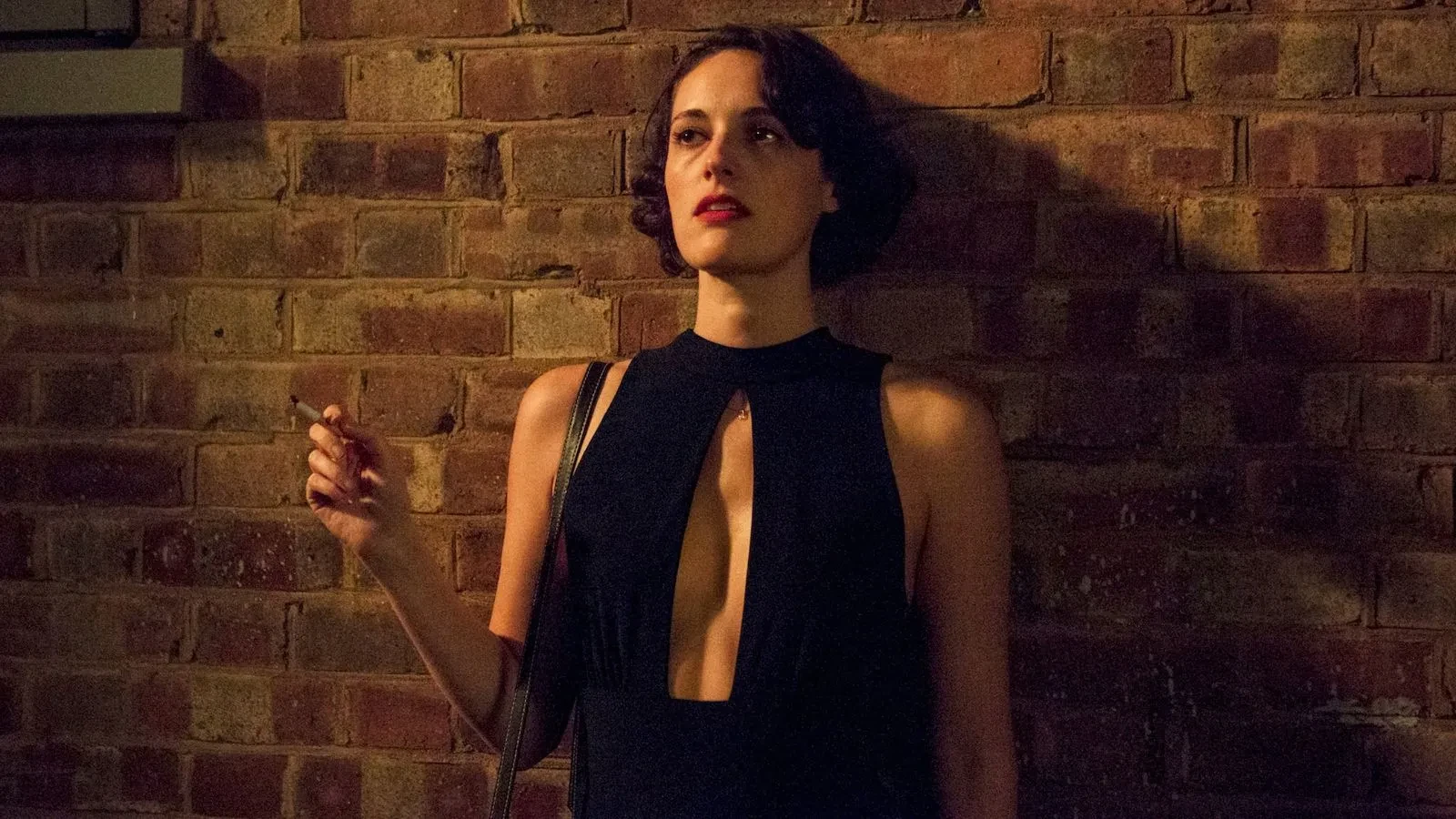  Promotional image for the TV series Fleabag. Phoebe Waller-Bridge as Fleabag stands alone at night against a dark brick wall
