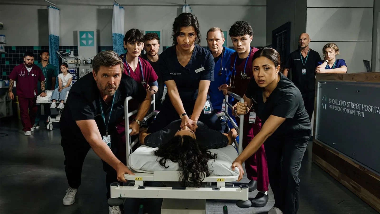 Promotional image for the medical soap opera Shortland Street, featuring an ensemble cast of doctors and nurses in a high-stakes hospital setting
