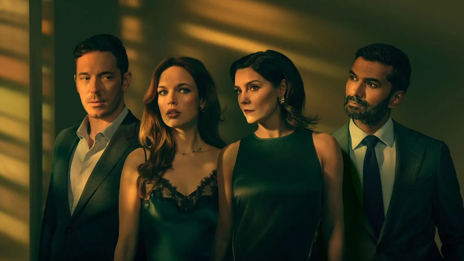 Two men and two women dressed smartly in a dimly lit room