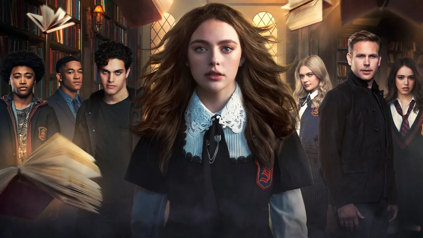 Danielle Rose Russel in Legacies wwith long brown hair wearing school uniform with classmates stood behind her in a library.