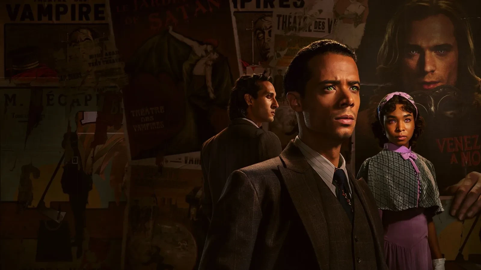 Three people dressed in vintage-style clothing stand in a dimly lit room with walls covered in old theatrical posters featuring words like “Vampire” and “Satan.” The figures wear formal suits and period dresses, evoking a dark, gothic atmosphere.