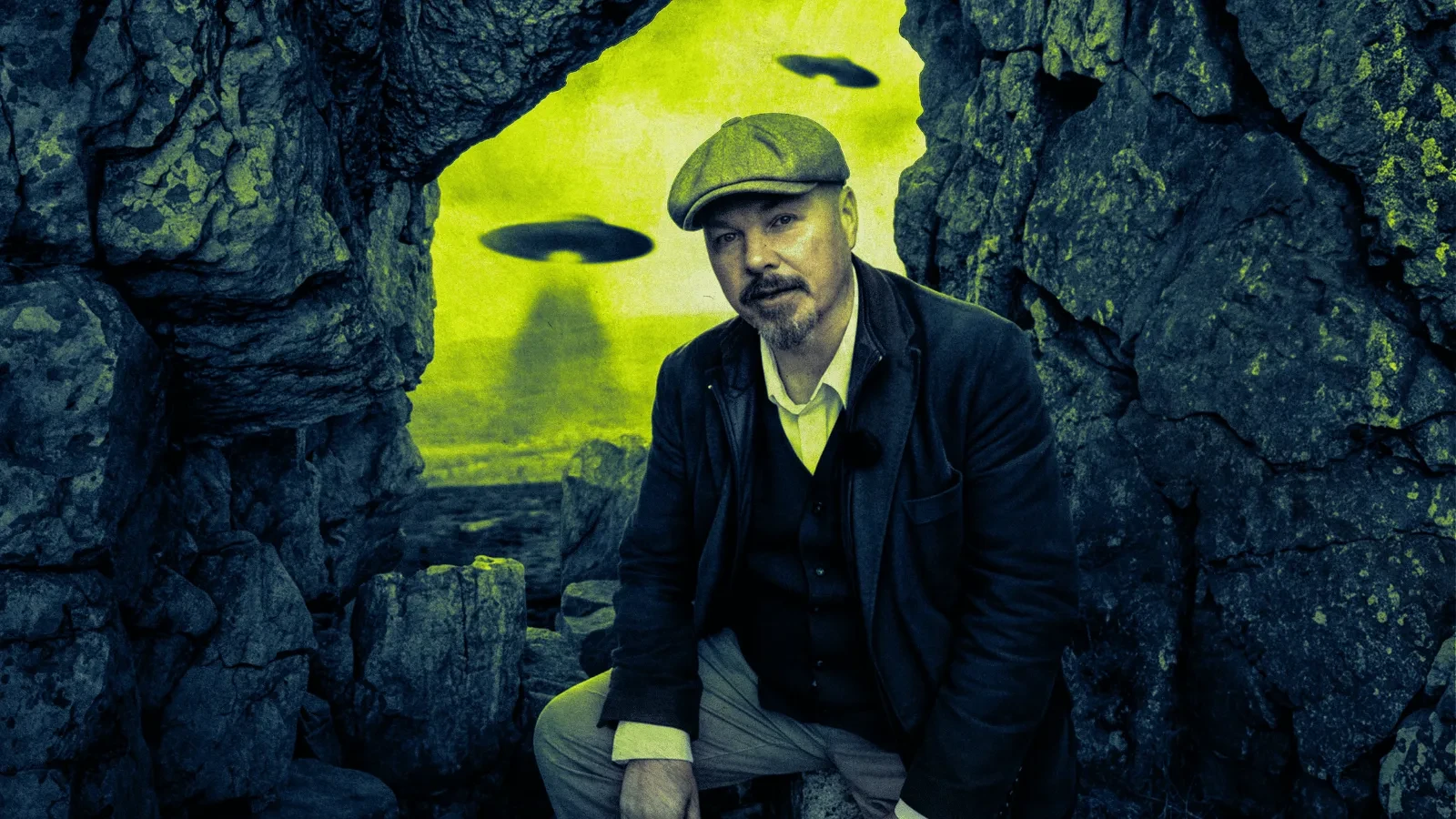 A person in a flat cap crouches between rugged rock formations, looking toward the camera, as several UFO-shaped objects hover in a bright, surreal green sky in the background.