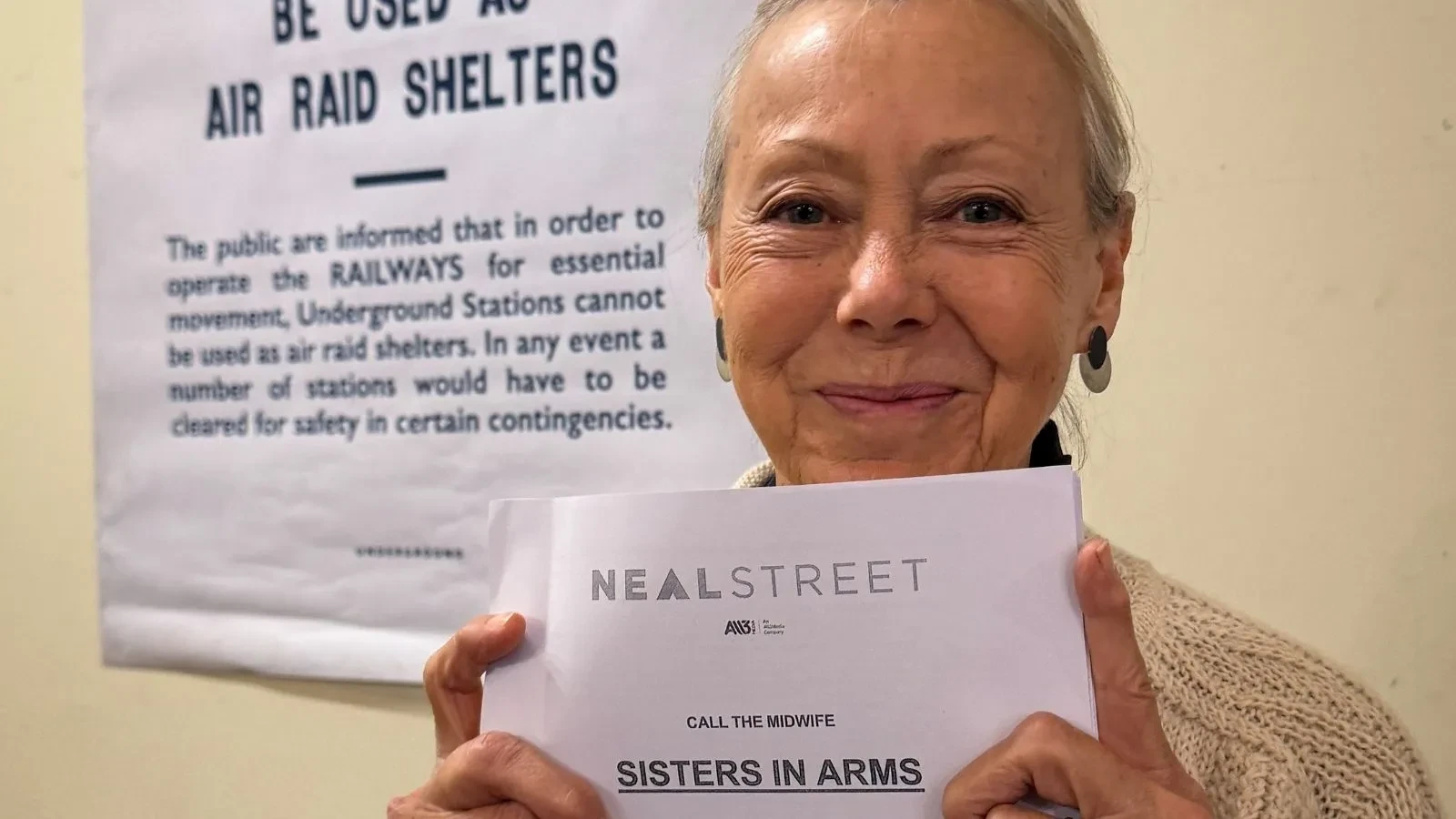 Generating response&nbsp;Copilot said: Sisters in Arms promotional image featuring a person holding a Call the Midwife: Sisters in Arms script in front of a historic wartime information poster, highlighting themes of healthcare, community, resilience and period drama set during World War II-era Britain.