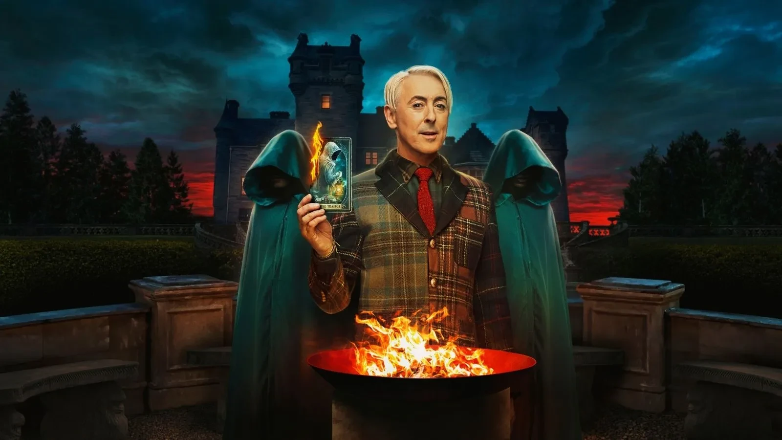 A person stands in front of a large country house at dusk, holding a card above a bowl of flames. Two hooded figures stand on either side, while dark clouds and dramatic lighting create a mysterious atmosphere.