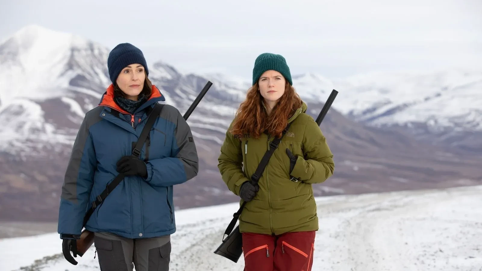 Vigil thriller series image of two investigators crossing a frozen Arctic landscape with rifles, set against dramatic snow-capped mountains and reflecting themes of mystery, suspense and survival.