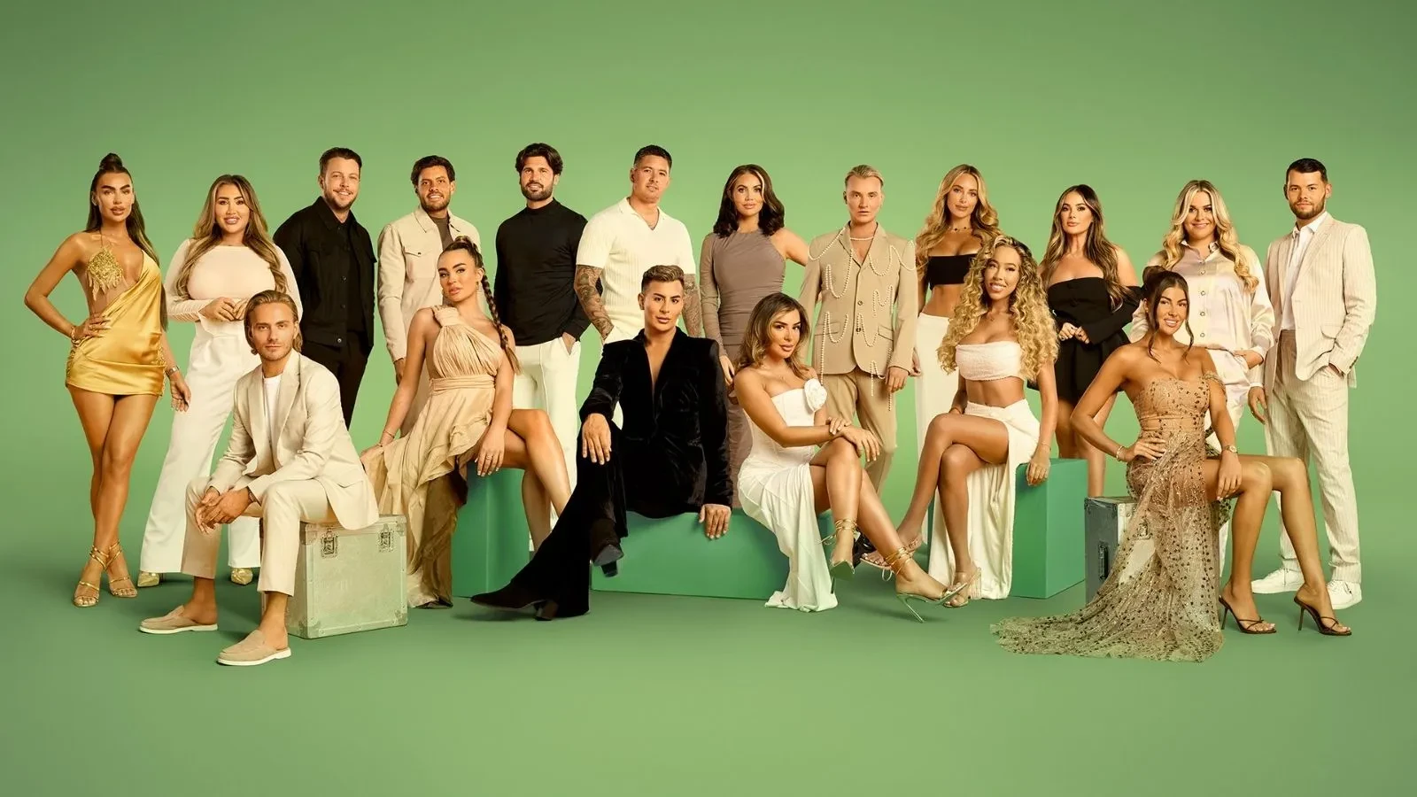 Promotional cast image for a reality TV series featuring a large group of contestants posed against a green studio backdrop. The cast wear coordinated neutral and gold-toned outfits, with some standing and others seated in a formal ensemble portrait.