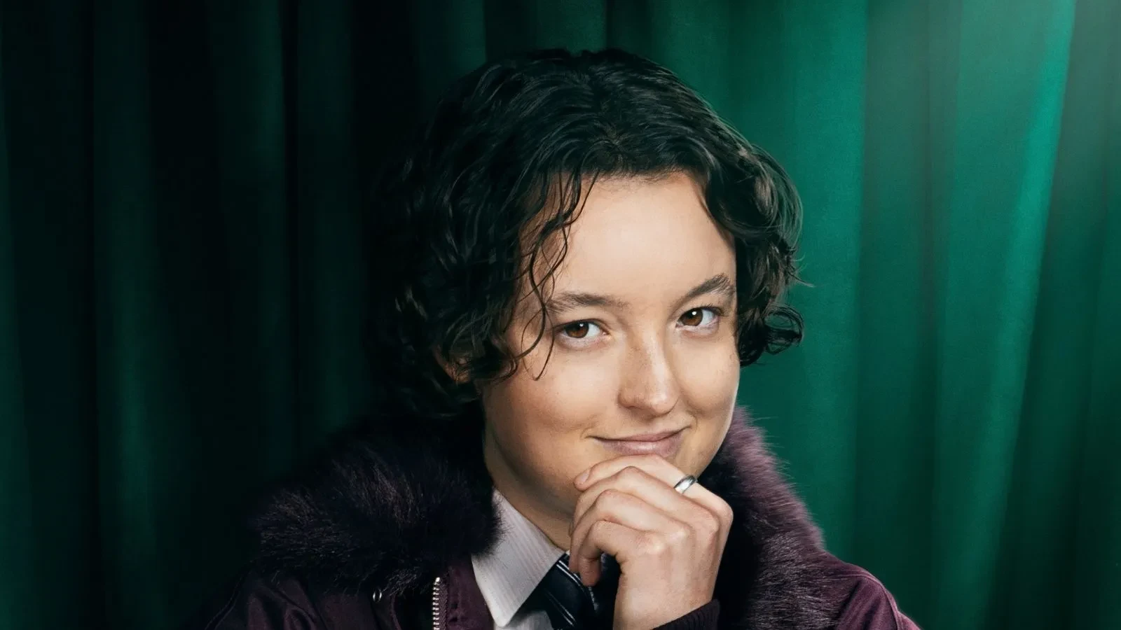 Bella Ramsay stood against a green backdrop in Celebrity Traitors