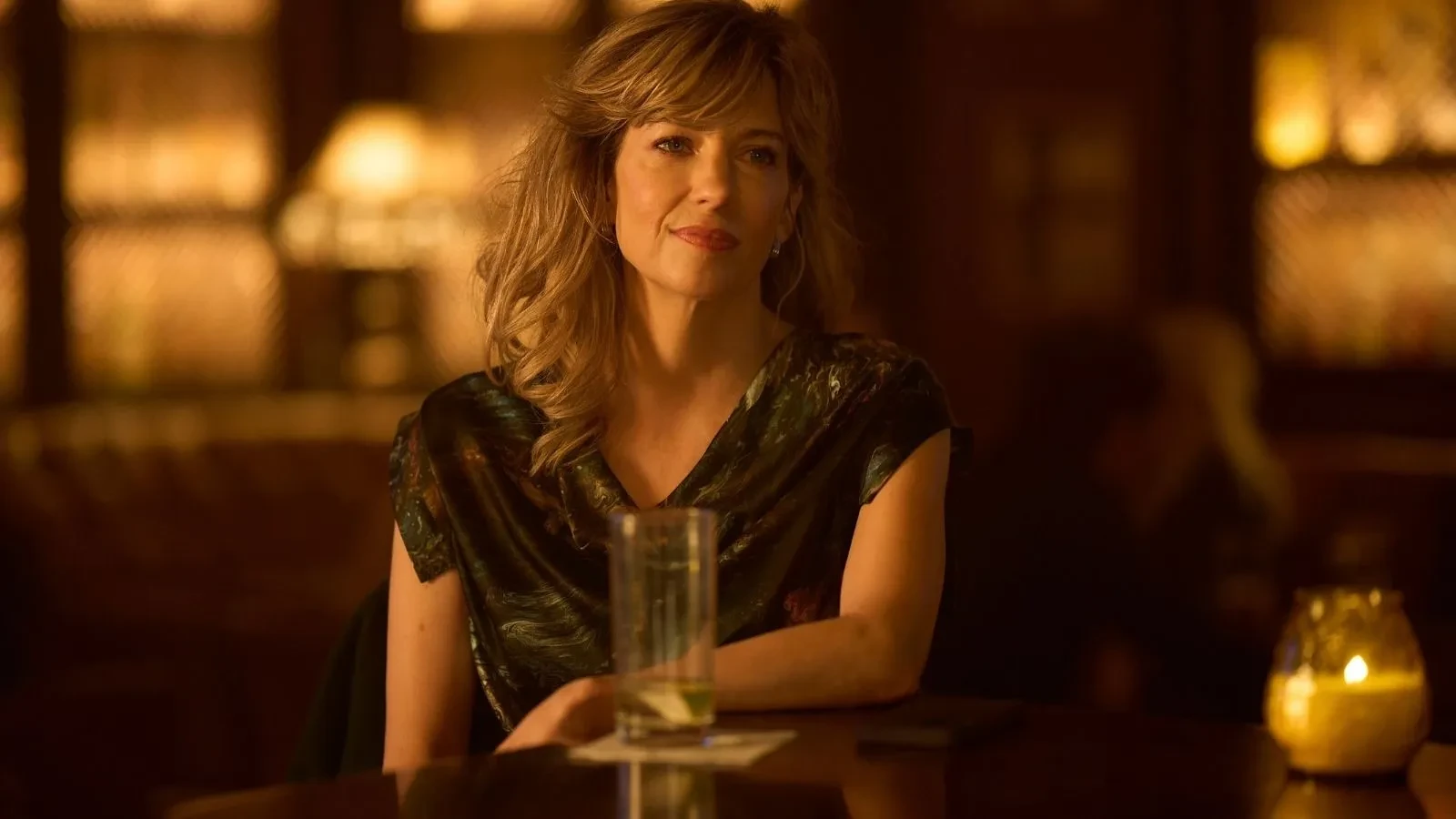 Lead character sits alone in a softly lit bar in thriller drama Complicit.