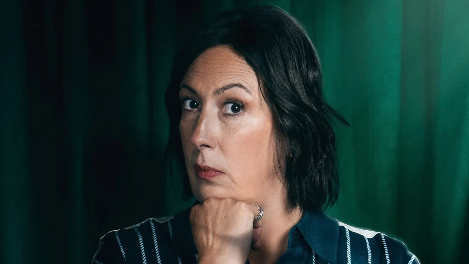 Miranda stood against a green background in Celebrity Traitors