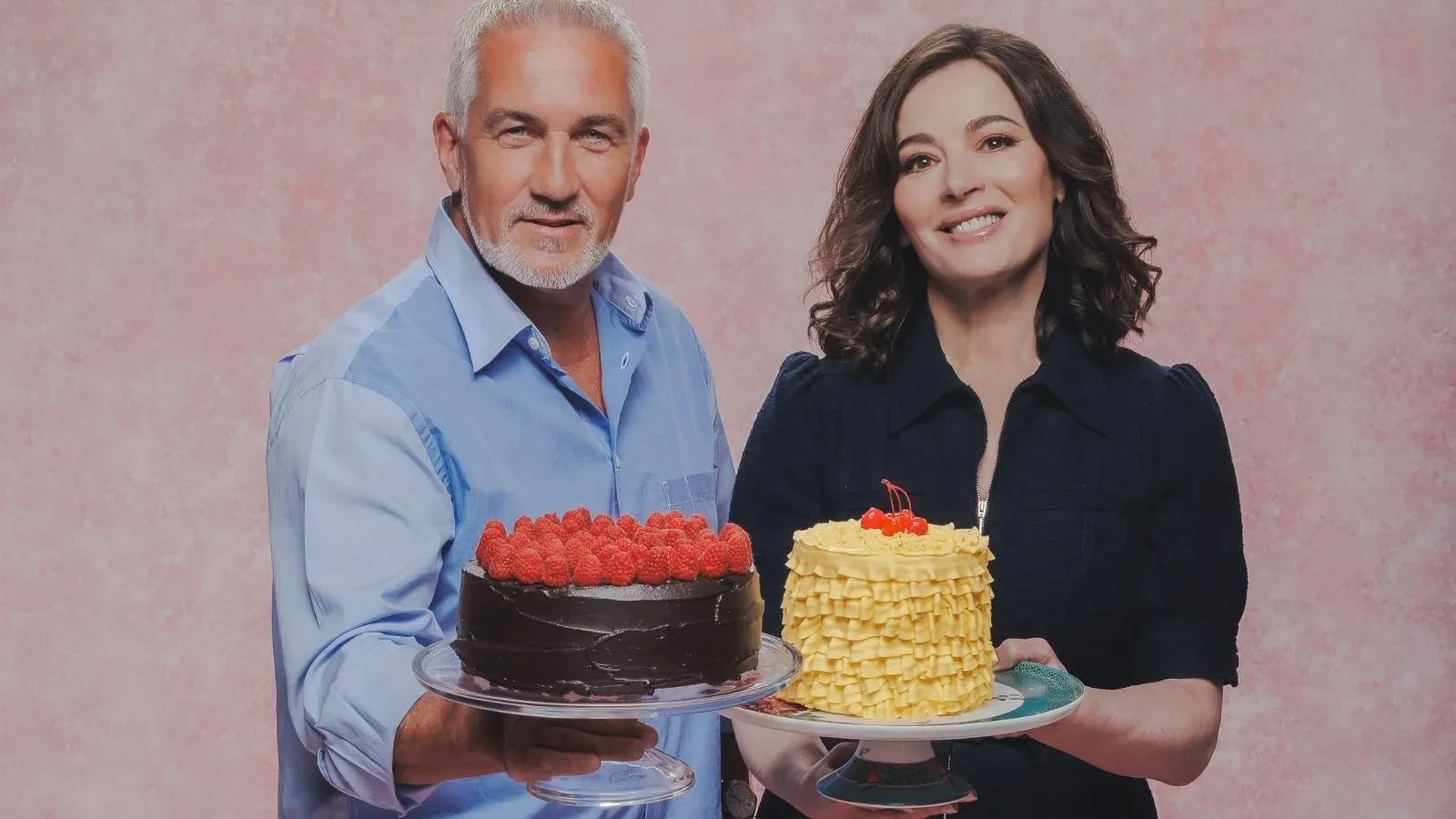 Great British Bake Off judges holding decorated cakes in an official GBBO promotional portrait.