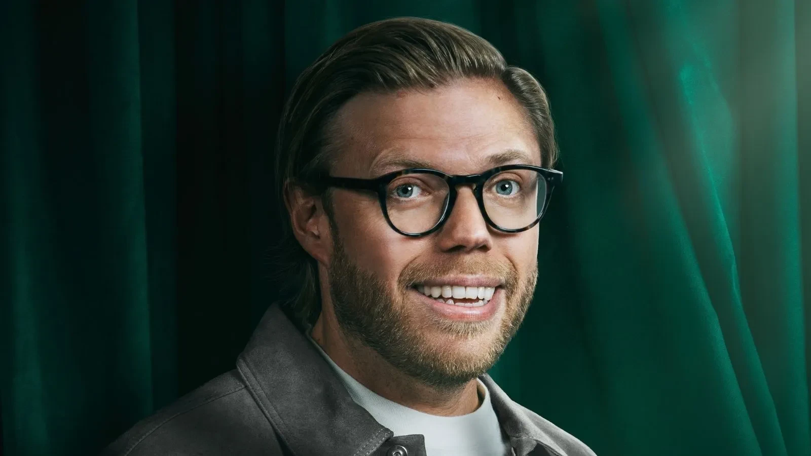 Rob Beckett stood against a green background in Celebrity Traitors