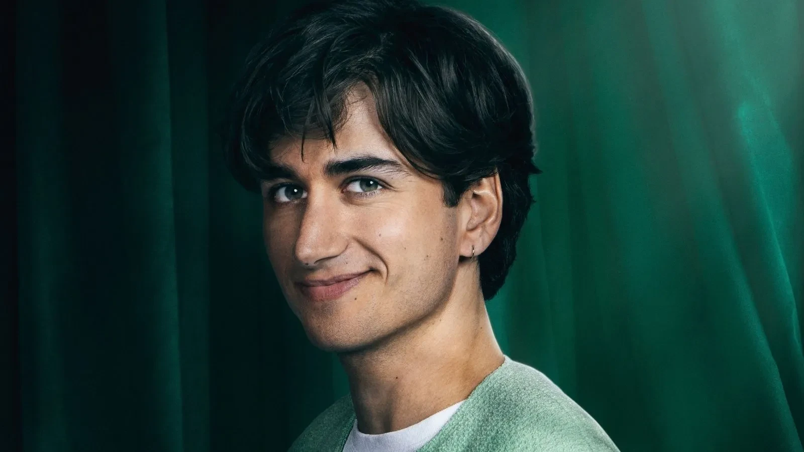 Sebastian Croft stood against a green background in Celebrity Traitors