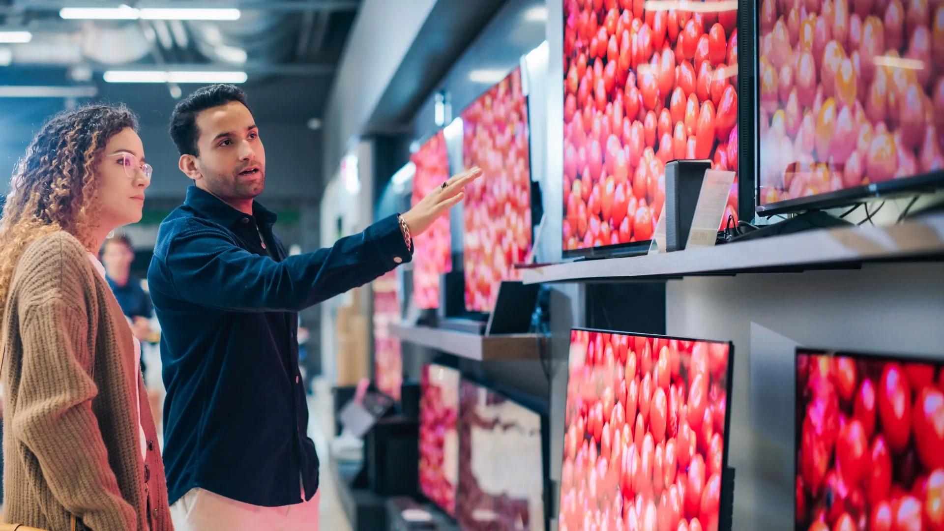 A person being shown televisions in a store