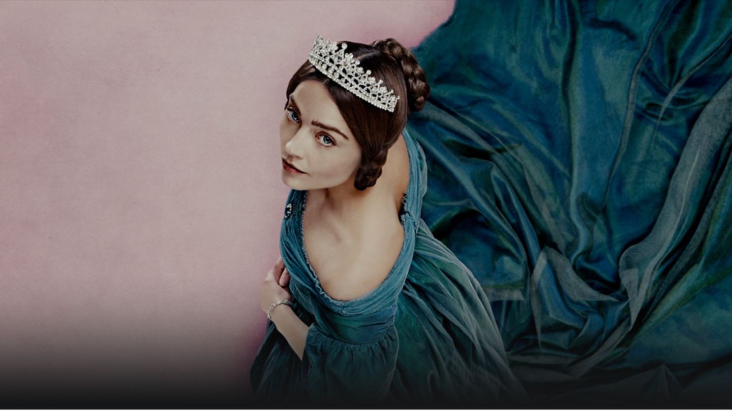  Promotional image for the ITV drama Victoria, featuring Jenna Coleman as the young Queen Victoria. The actress is shown wearing a jeweled crown and a teal velvet gown