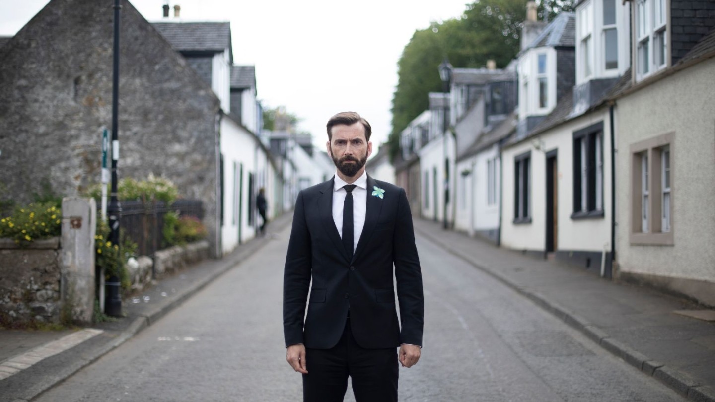 David Tennant stood in the middle of a street in Deadwater Fell