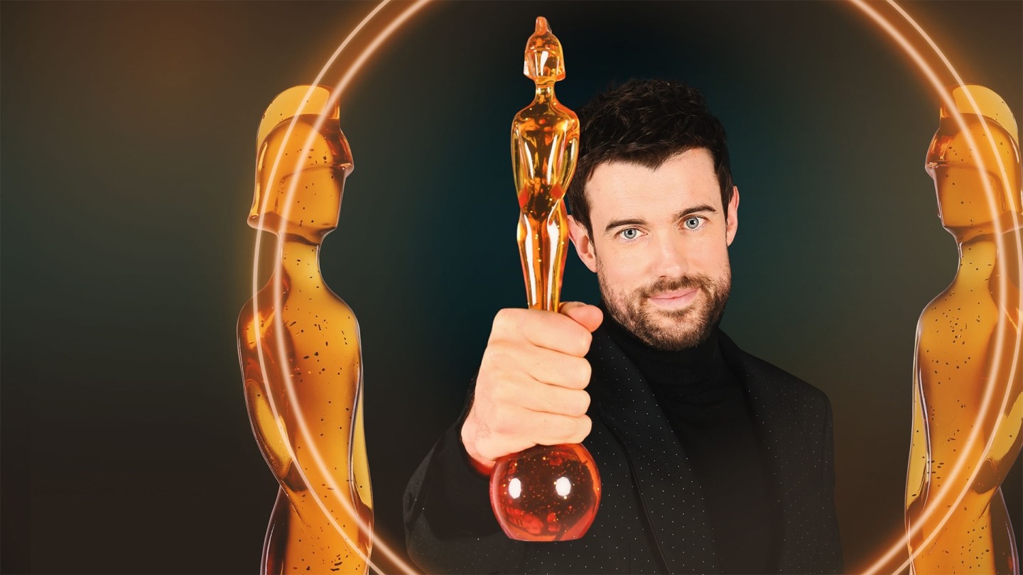 Person holding a golden award trophy in the foreground, framed by two stylised golden statuette figures and glowing circular light effects on a dark background