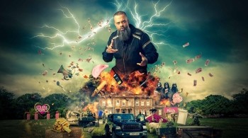 A bald man with a beard on top of an exploding house with lightening behind him and a chaotic scene below