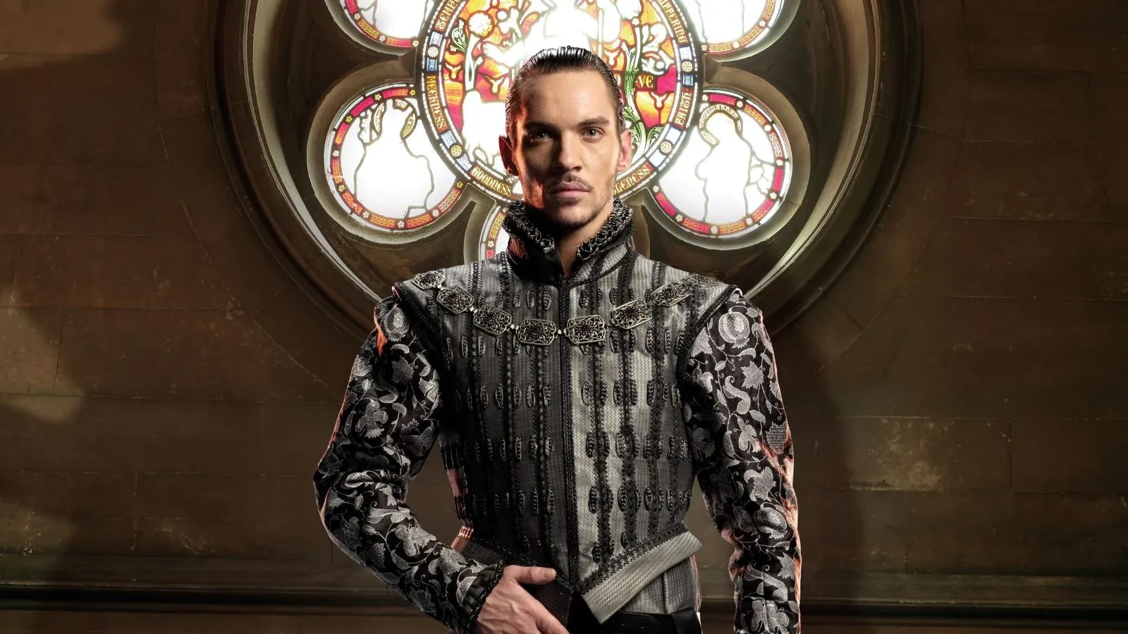 A man wearing royal robes with his right arm in front of his belt