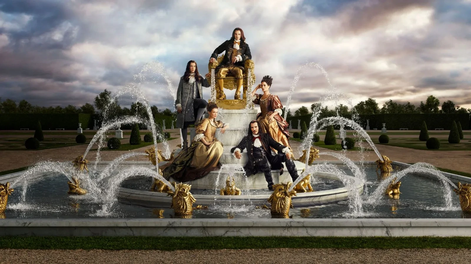 A man and two women sat on a golden fountain 