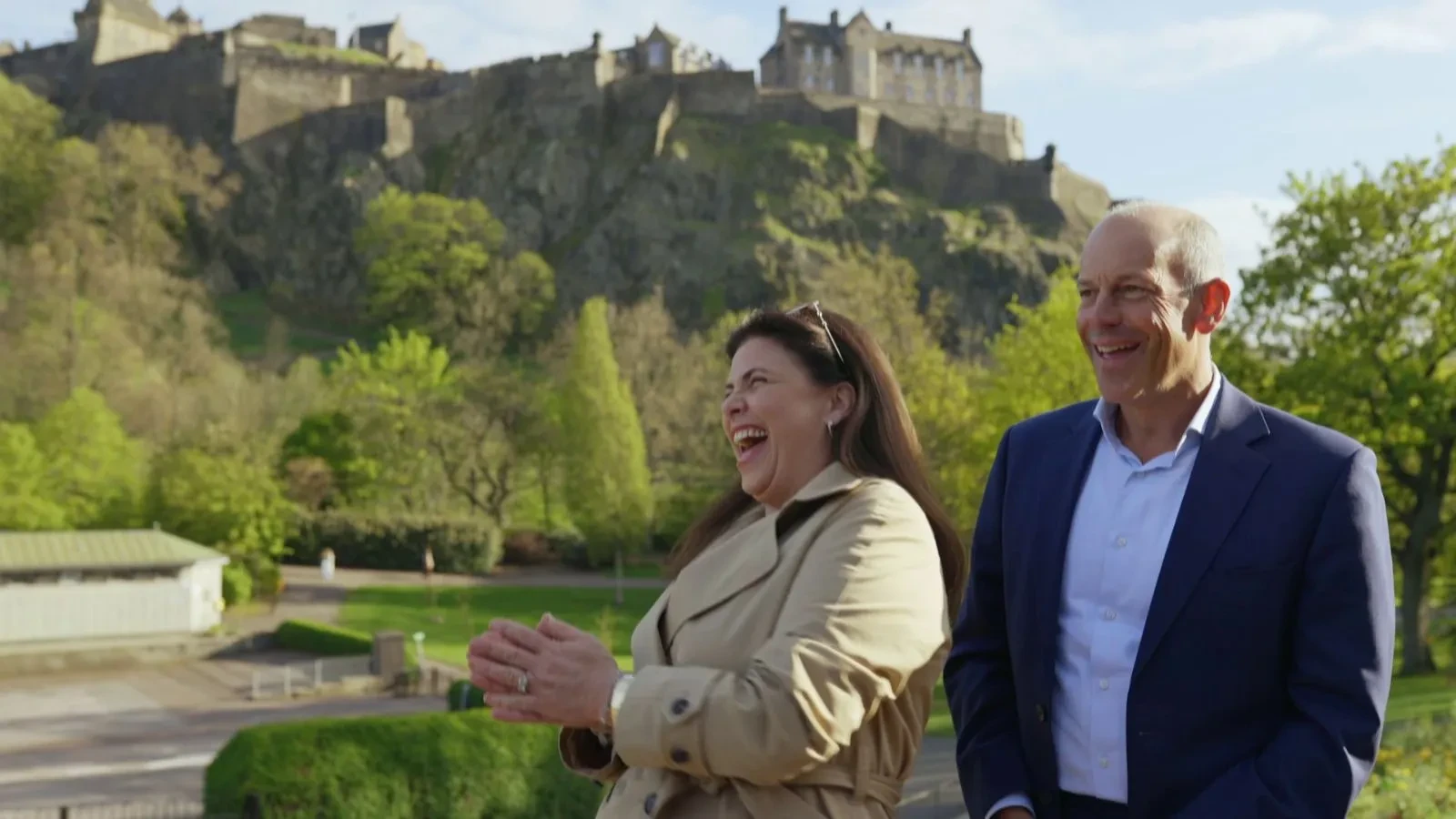 A man and a women stood with a castle in the background