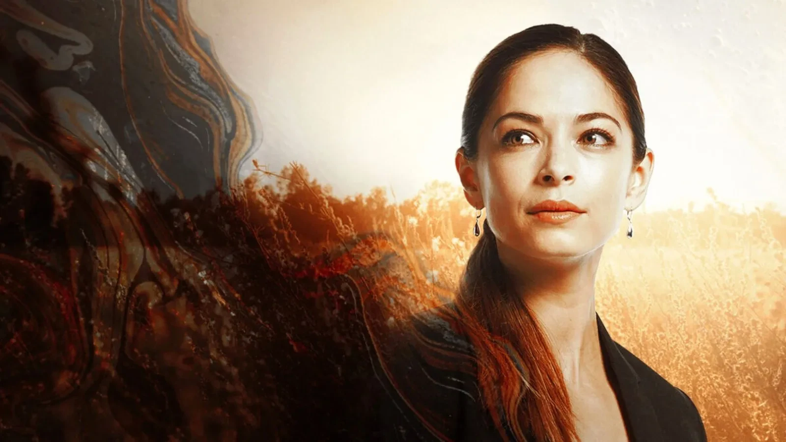 A women stood in front of a field with a blazer looking to the left of the photo