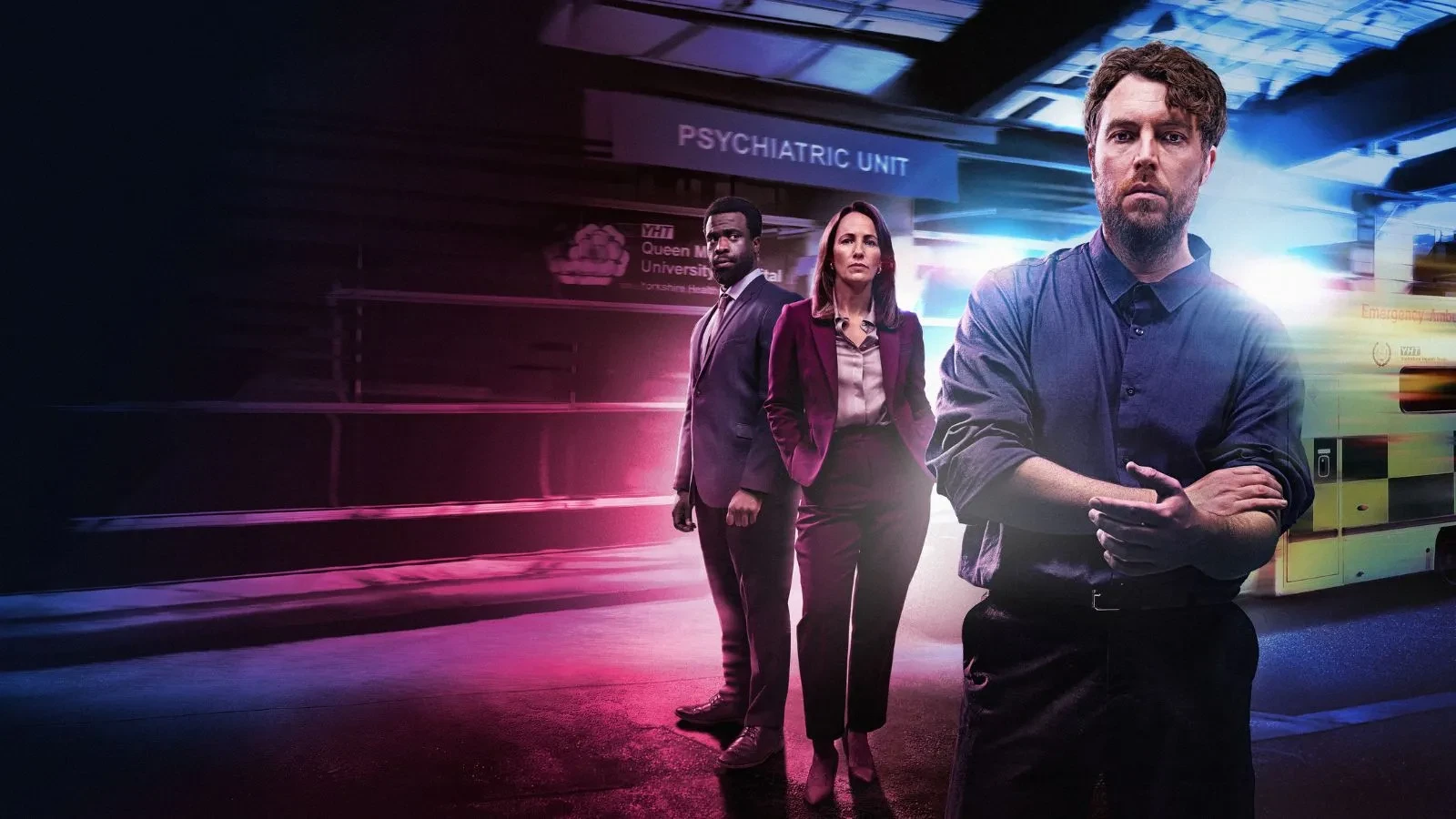 A man stood in the foreground with two others stood in the background in a building