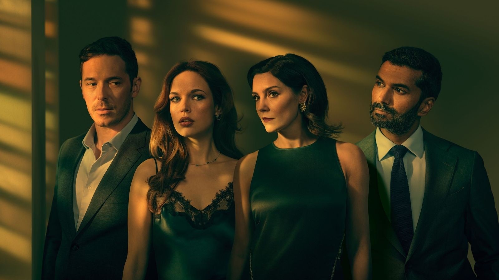 Two men and two women dressed smartly in a dimly lit room