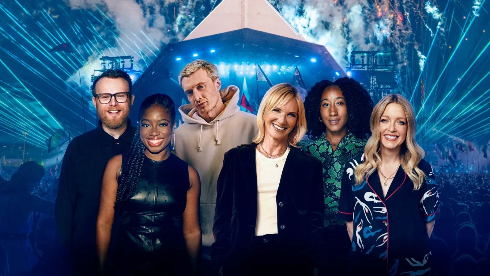 Four women and two men smiling stood in front of a festival tent with blue lights in the background