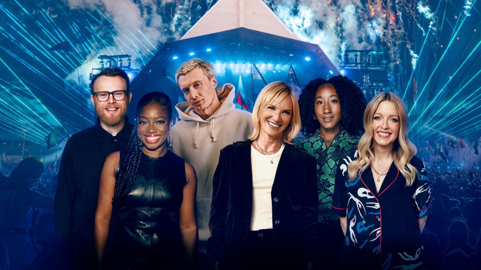 Four women and two men smiling stood in front of a festival tent with blue lights in the background