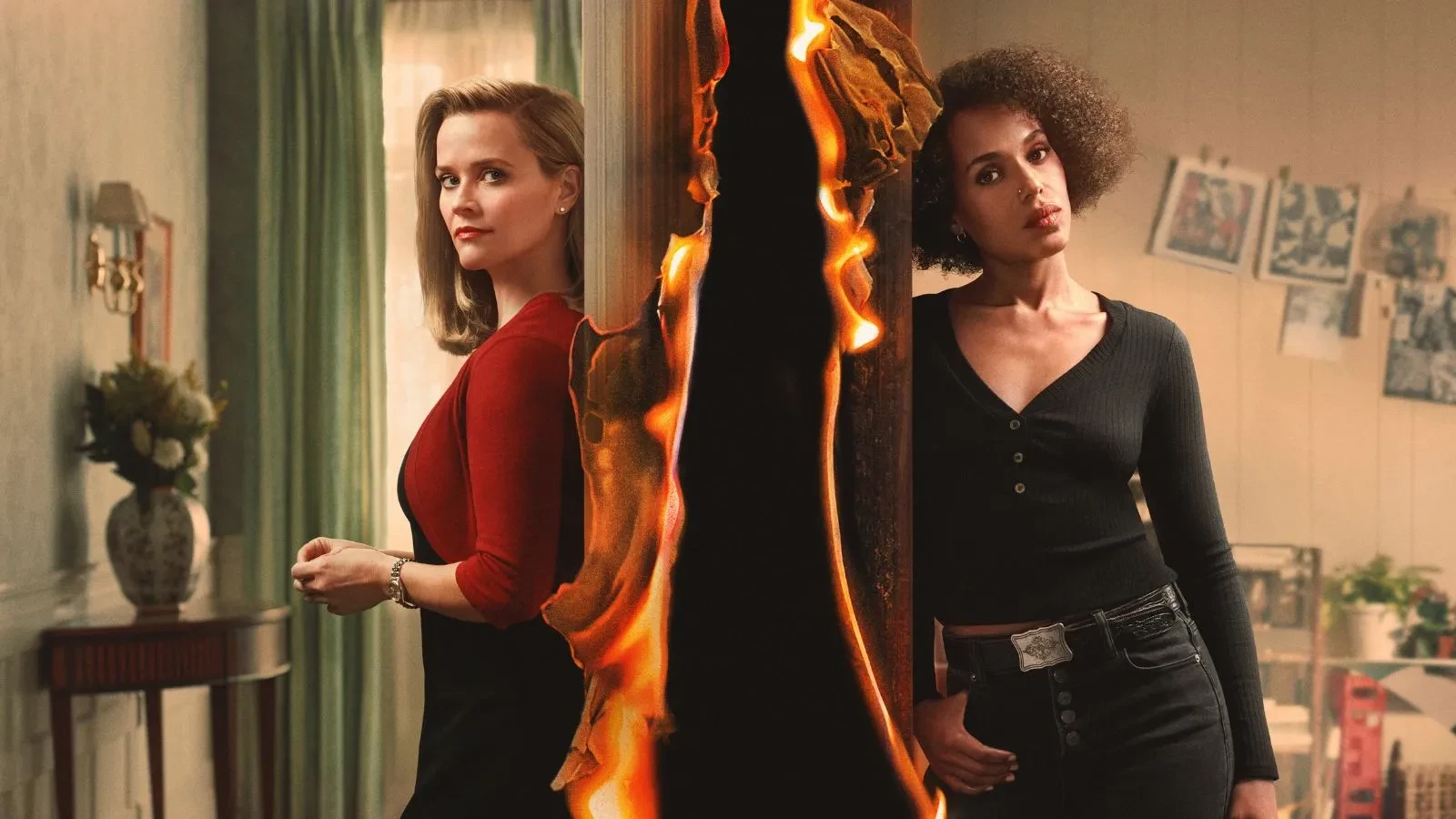 Two women stood against a wall with fire between them