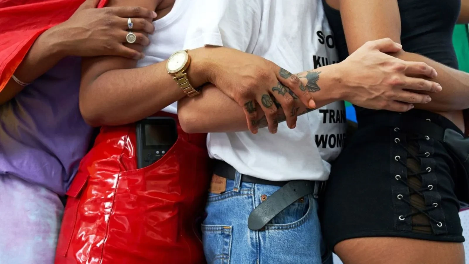 Four people from their chest to mid thigh stood sideways with different styles of clothing on