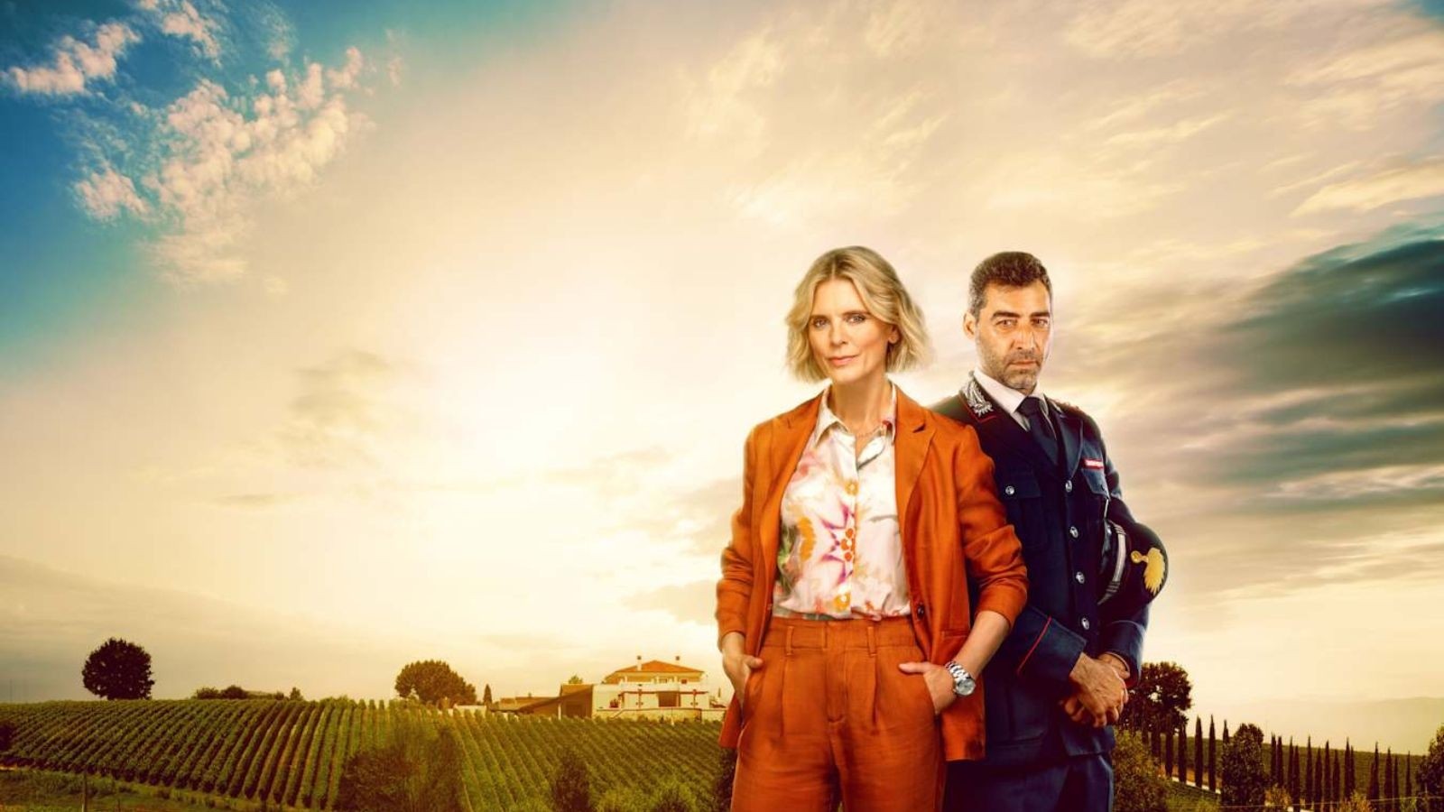 A women in a red suits with an Italian officer next to her and a nice sunny background