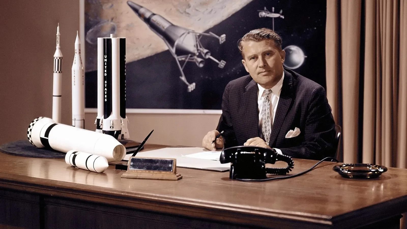 A man sat at desk with a model rocket in the documentary Nasa, Nazis and the space race