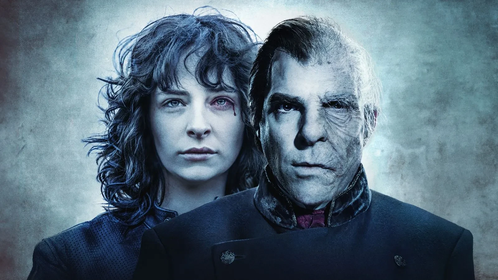 Black and white image of a brunete women with curly hair staring into the camea with blood dripping out of her left eye stood behind a man with a disfigured face.