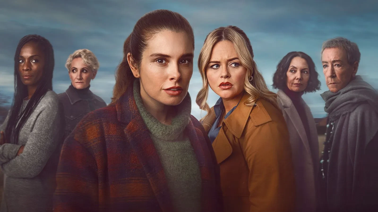 5 women stood in a field against a blue background wearing cardigans and jackets all staring accusingly at each other