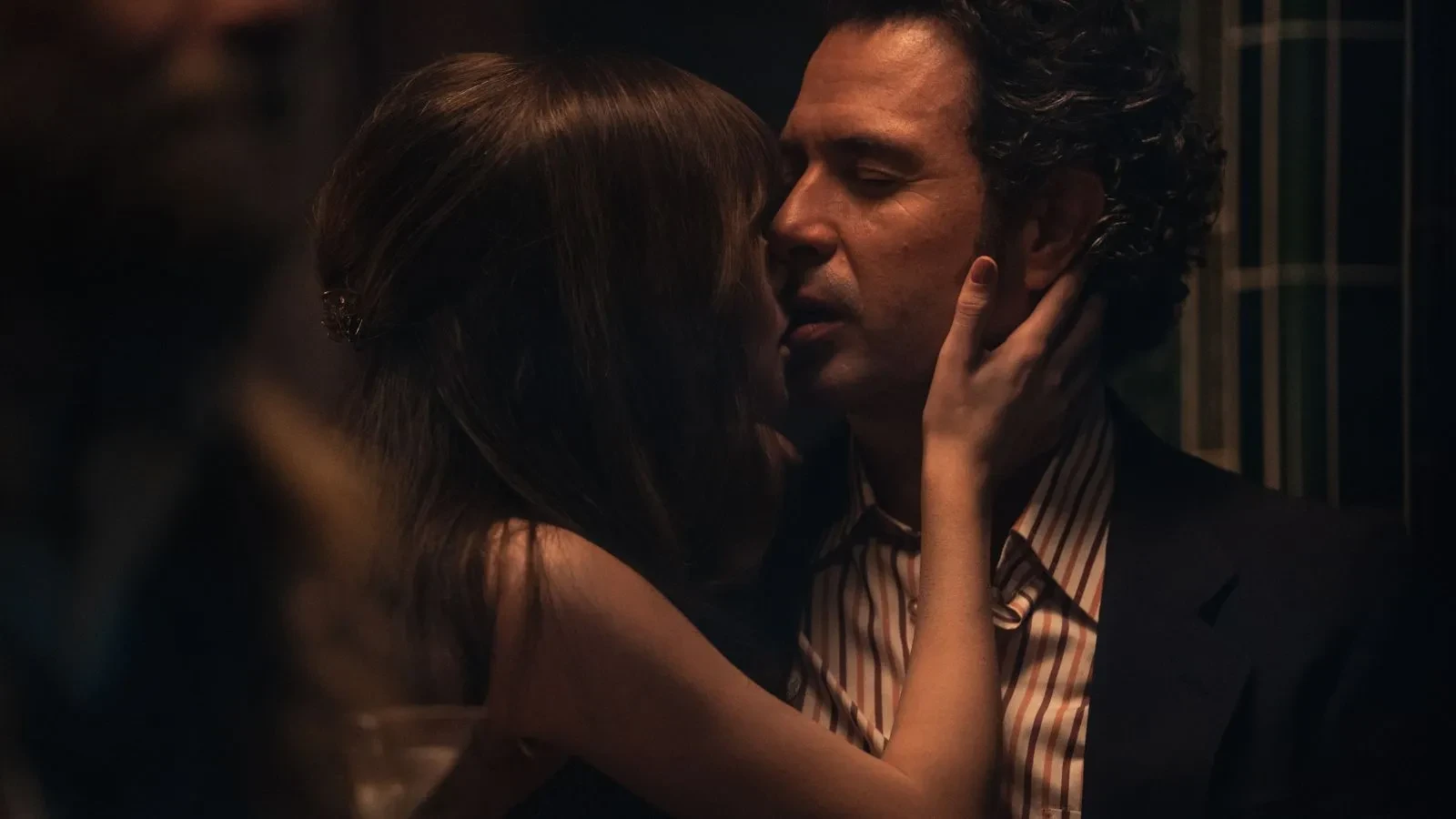 A brunette women with her back to the camera and her right hand on Tom Cullen's face in the drama Trespasses