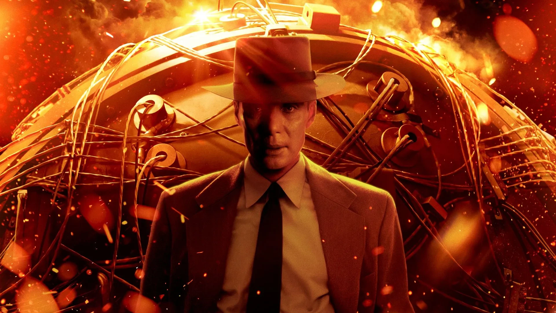 Poster art for the film Oppenheimer, showing a man in a suit and fedora standing before a glowing, fiery backdrop and a complex mechanical device, evoking themes of nuclear science and historical drama.