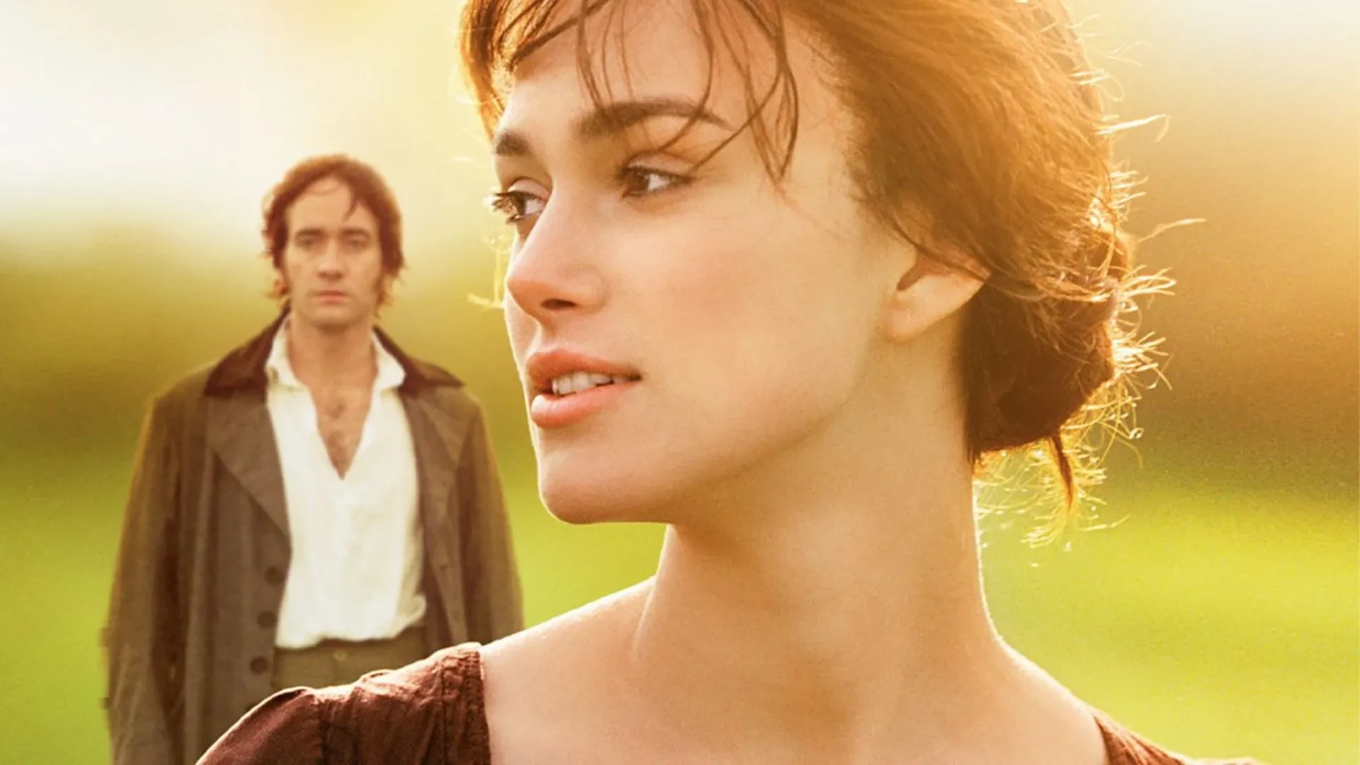 Promotional image for the film Pride and Prejudice (2005), showing a woman in period dress in the foreground and a man in the background, set against a warm, outdoor landscape.