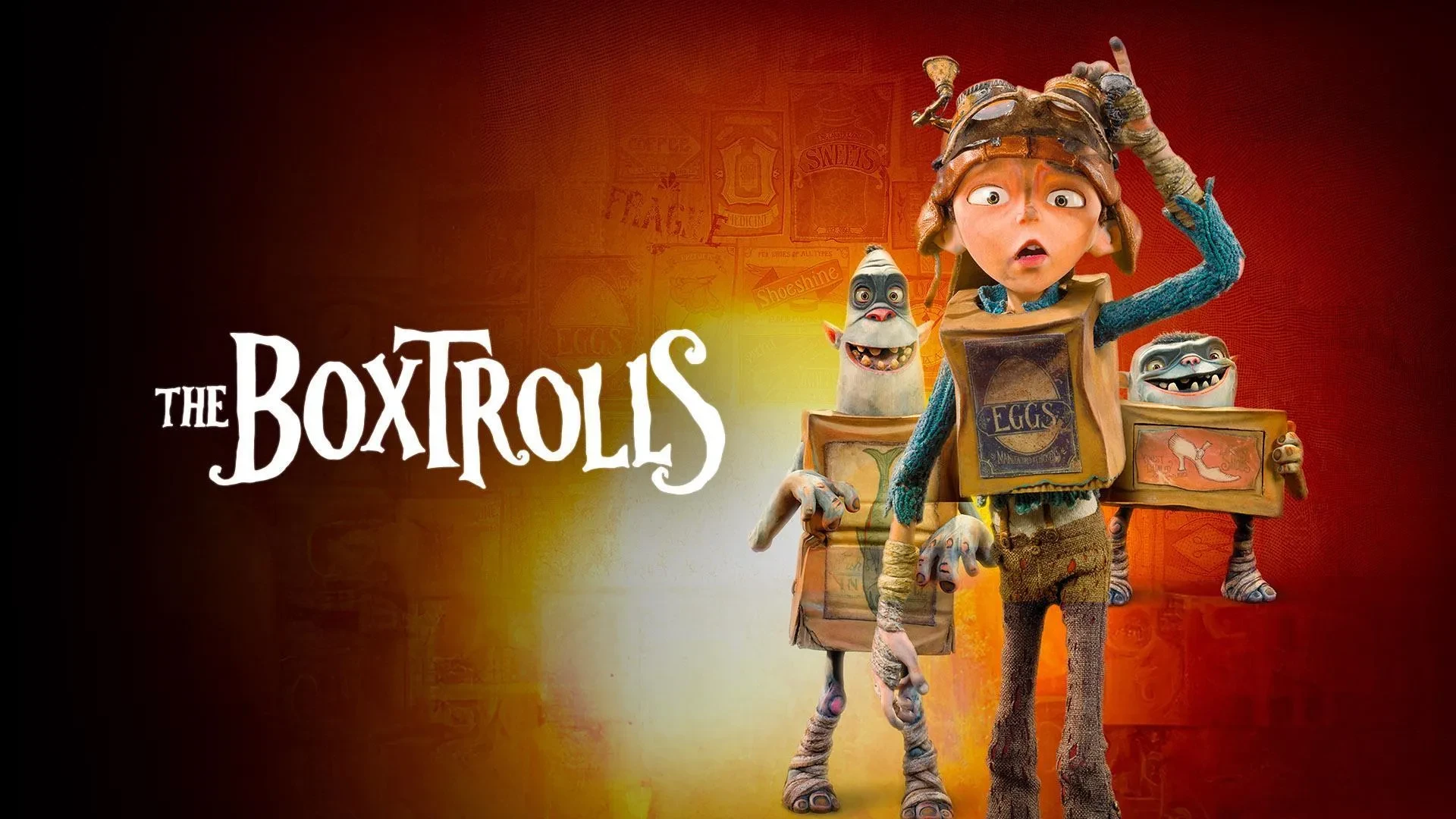 Poster image for the film “The Boxtrolls”, showing three animated characters wearing cardboard boxes with labels, standing against a red and yellow gradient background with the film title on the left.