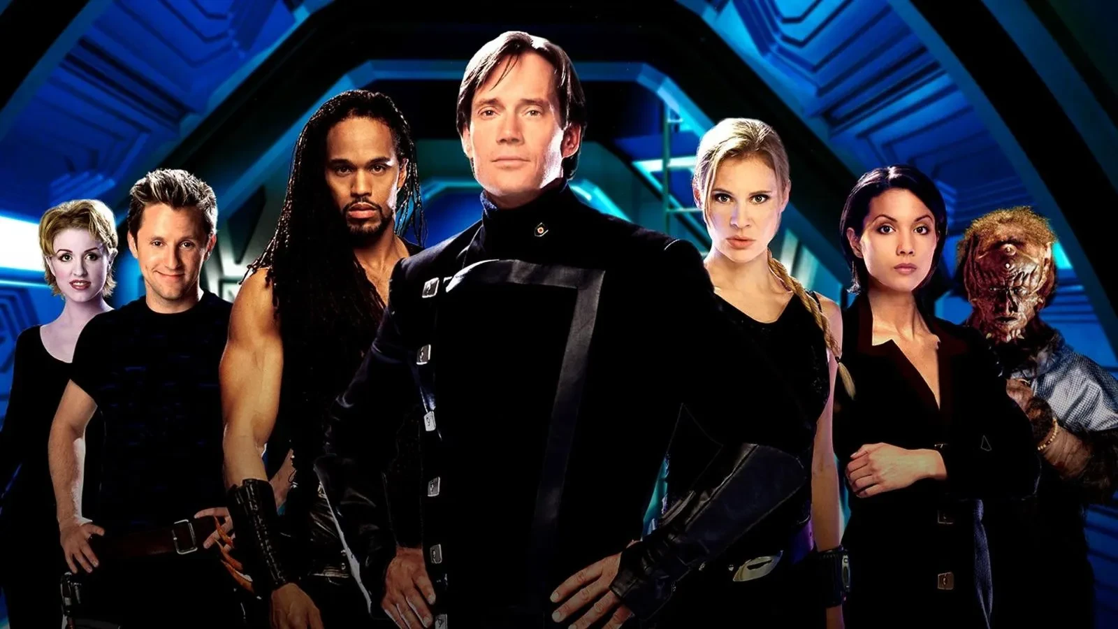 A group of seven people dressed in futuristic, sci‑fi style uniforms standing together inside a sleek, blue‑lit spaceship interior, creating a dramatic and heroic ensemble scene.