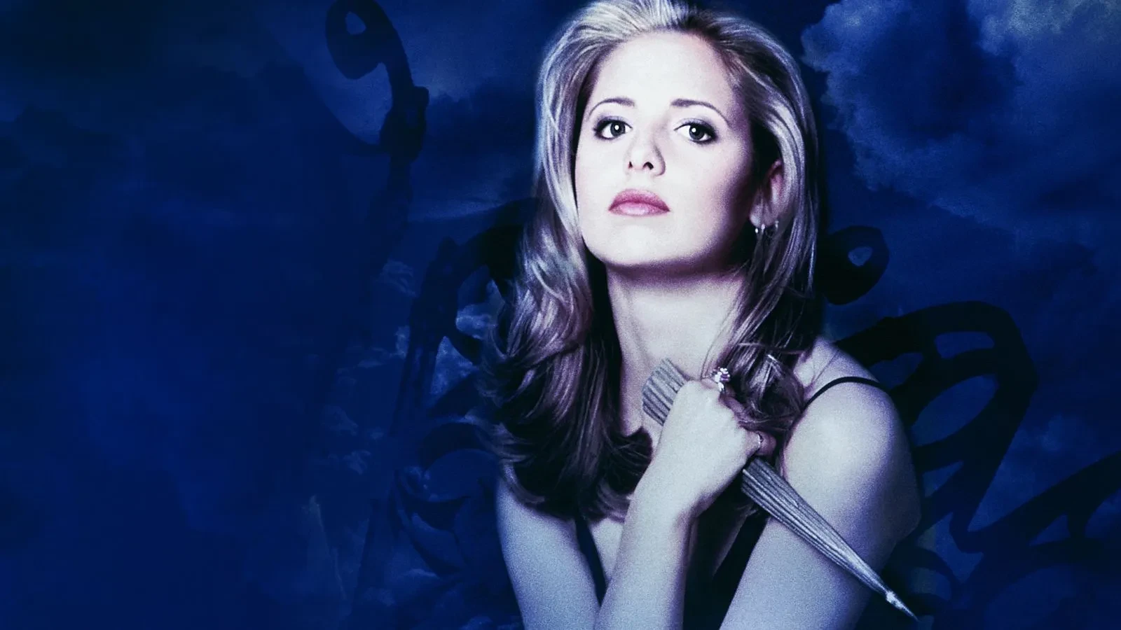 A woman with long blonde hair holding a wooden stake against a dark, moody blue background with swirling shadowy shapes, creating an atmospheric supernatural and dramatic scene.