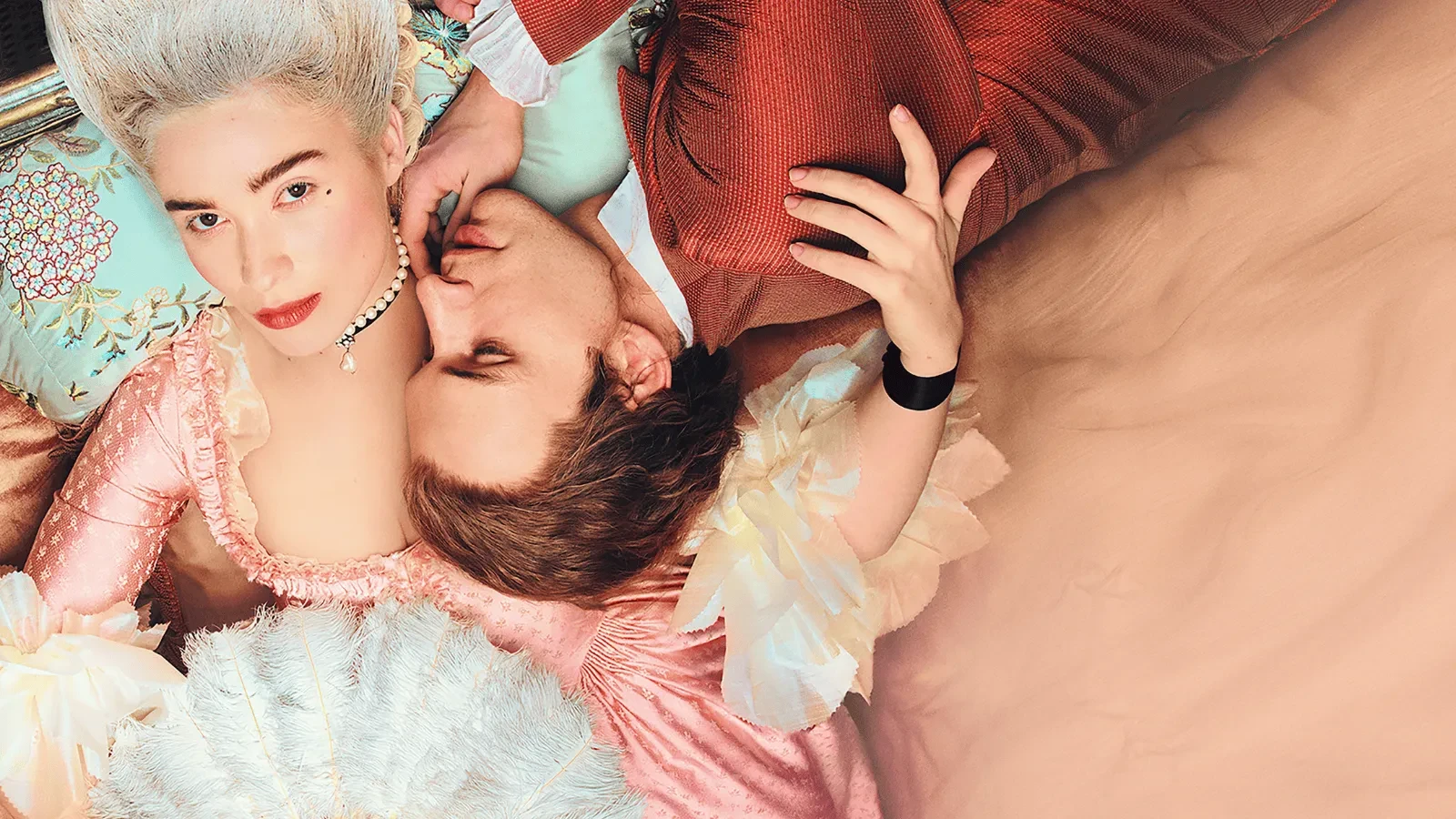 A man and woman in period clothing lying in a pink bed in the drama Dangerous Liasons