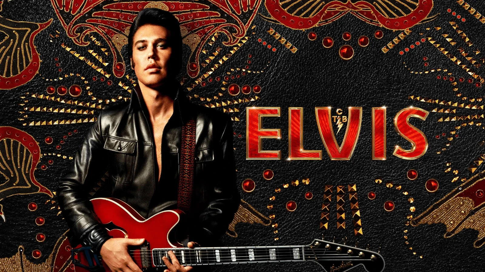 Person wearing a black leather jacket holding a red electric guitar in front of an ornate black and gold backdrop with the word ‘ELVIS’ in bold red lettering.