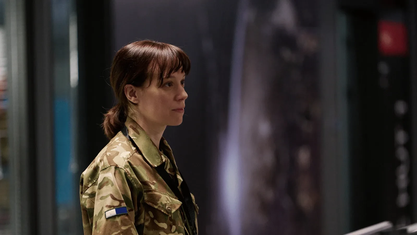 Individual in military camouflage uniform at a secure intelligence facility in The Undeclared War, highlighting national cybersecurity and defence operations.