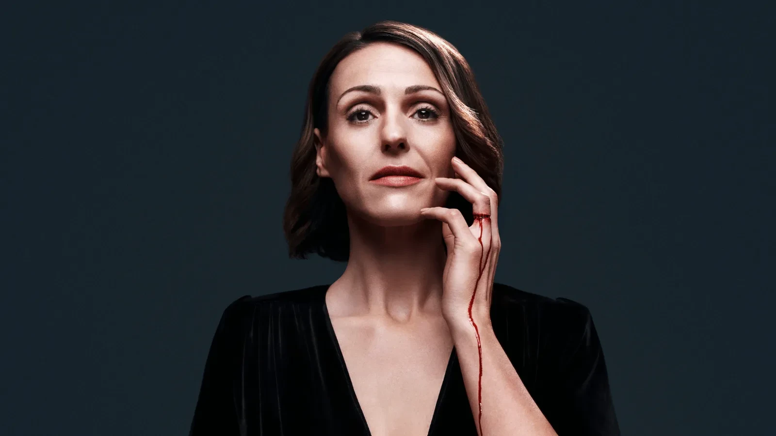 Suranne Jones against a black background with blood dripping doww her arm in the new season of Doctor Foster
