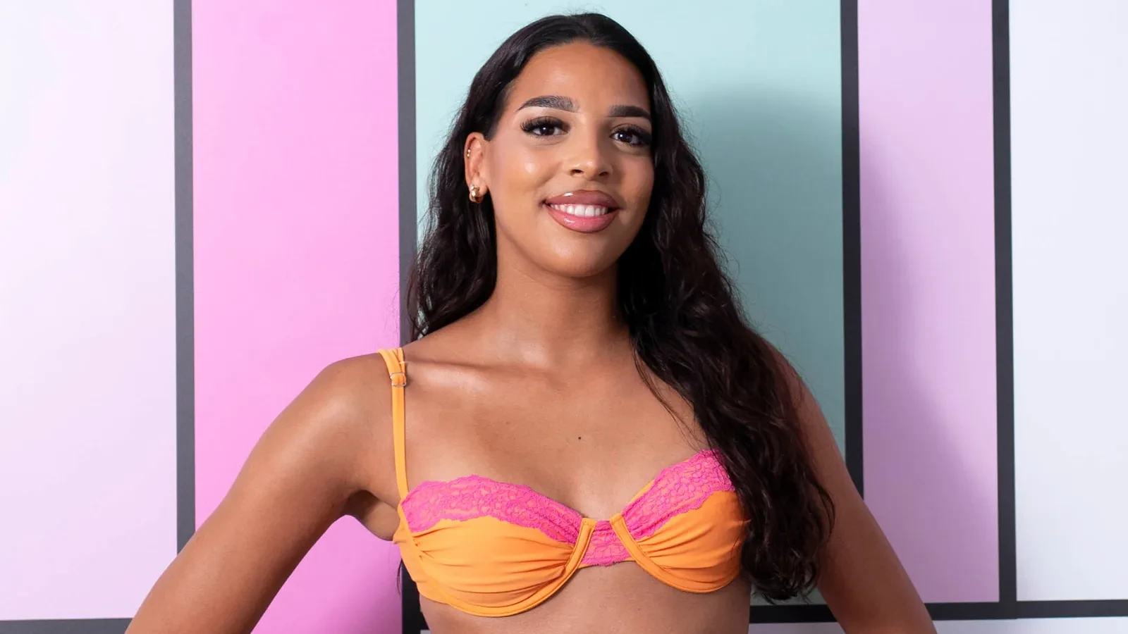 Nevah David  stood against the colourful Love Island background