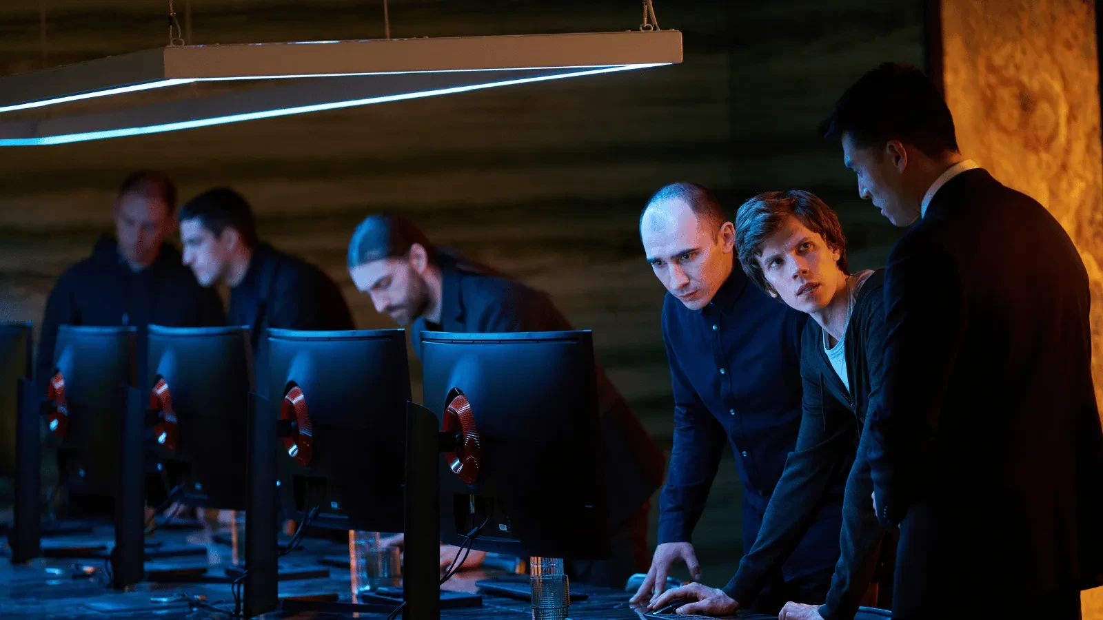 Cybersecurity analysts monitoring multiple computer screens in a high-tech operations center during a cyber incident response investigation.